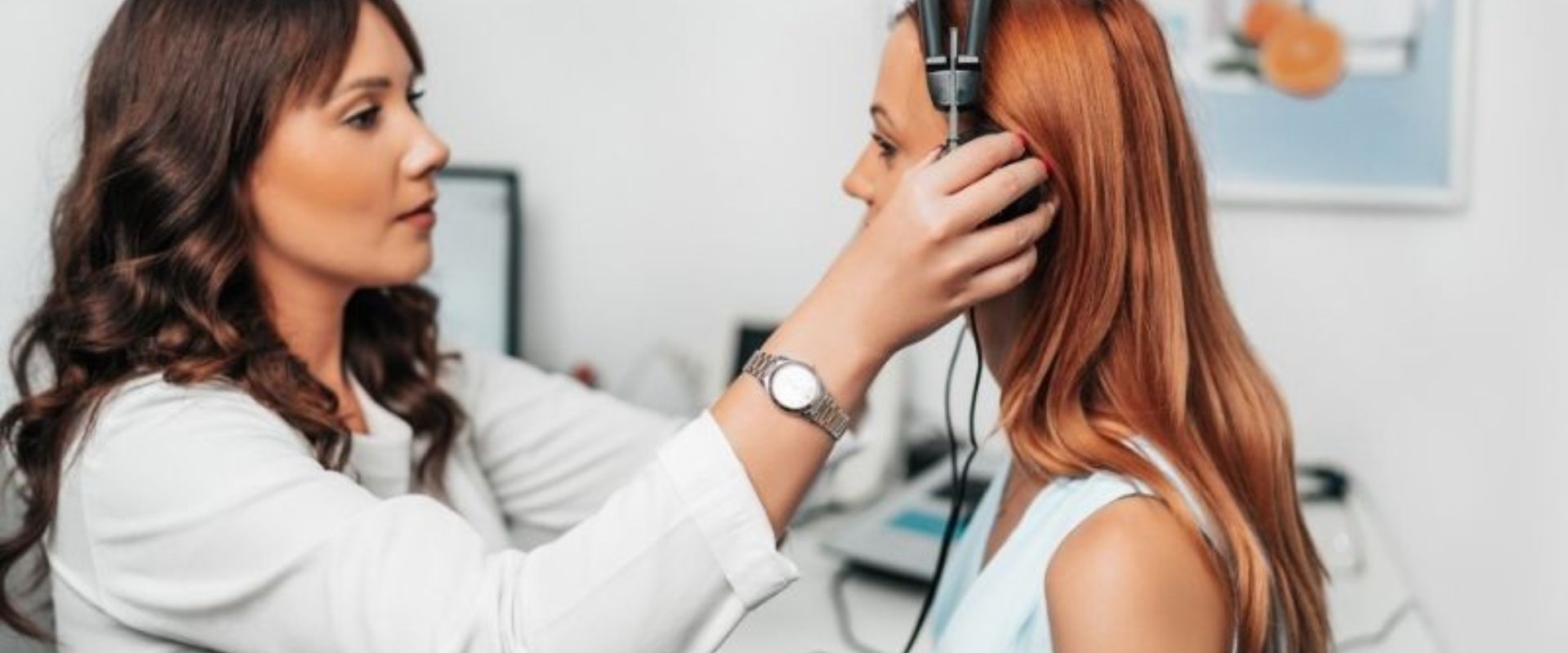 Fonoaudióloga realizando audiometria em paciente dentro de cabine acústica na clínica Auditif Sorocaba, equipamento calibrado, paleta azul-marinho, fotografia realista